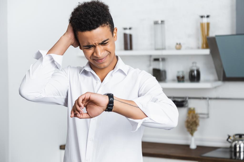 στρεσαρισμένος Αφροαμερικάνος κοιτάζει το ρολόι στο χέρι - Φωτογραφία, εικόνα