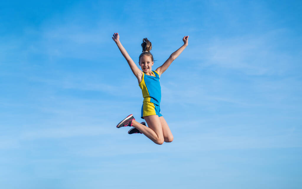 stretching and warming up. childhood happiness. health and fitness. gymnastics. sense of freedom. happy teen girl jump on sky background. kid has flexible body. child in sport clothes training - Photo, Image