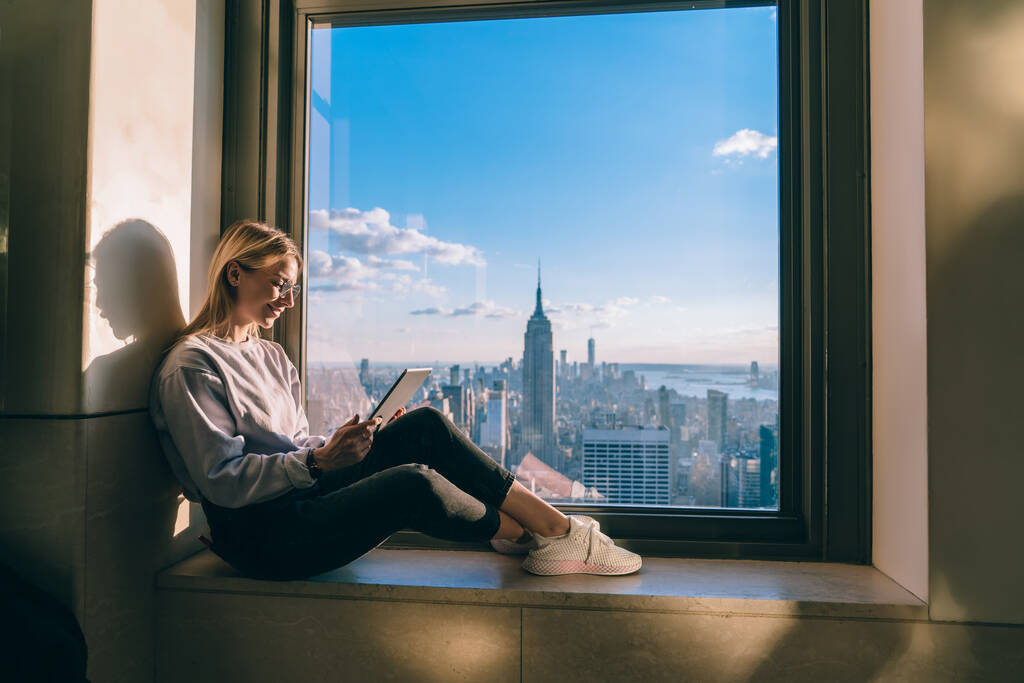 Onnellinen nainen freelancer tarkkailun tietoja katsellessaan purojen videon kautta moderni kosketuslevy 4g, hymyilevä hipster turisti lukeminen teksti julkaisu matka neuvonantaja tutkia New York - Valokuva, kuva
