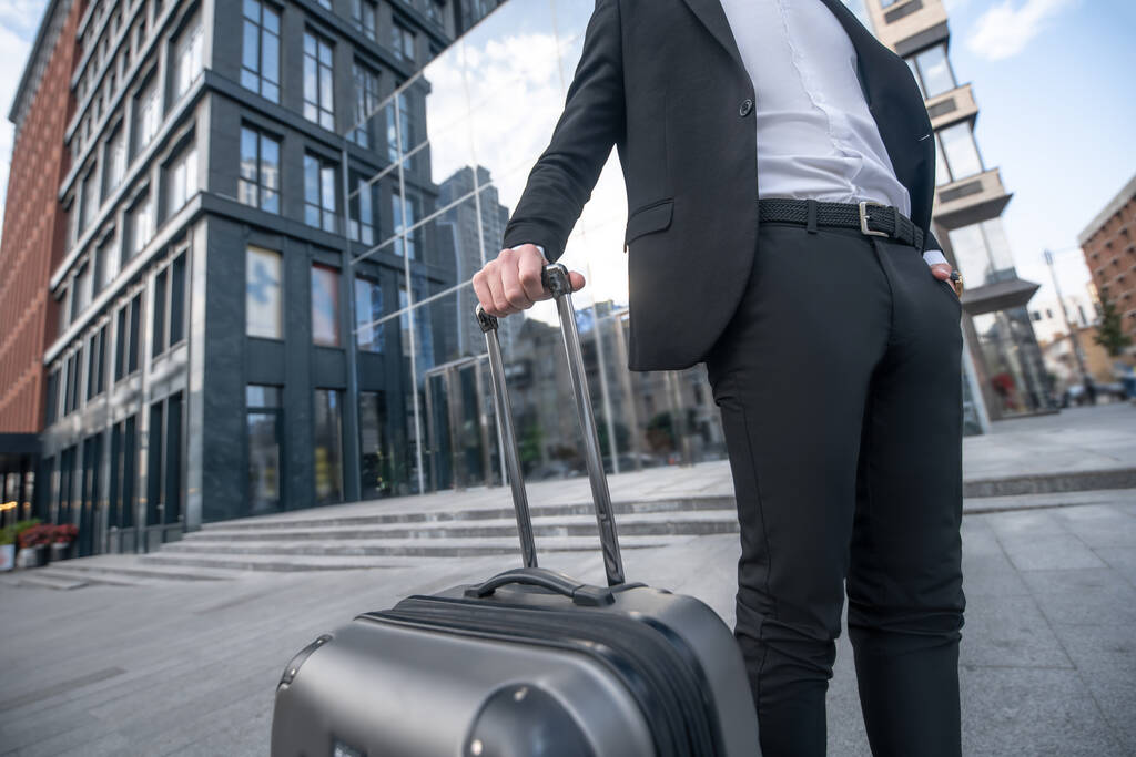 Крупный план человека в черном костюме и чемодане - Фото, изображение