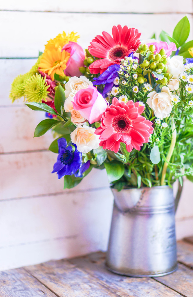 Colorful bouquet of spring flowers in vintage vase on rustic wooden background - Photo, Image