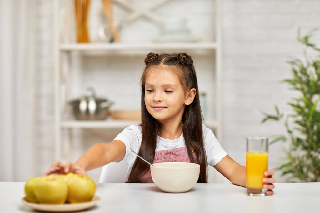 menina pequena bonito tomando café da manhã - cereal e suco de laranja - Foto, Imagem