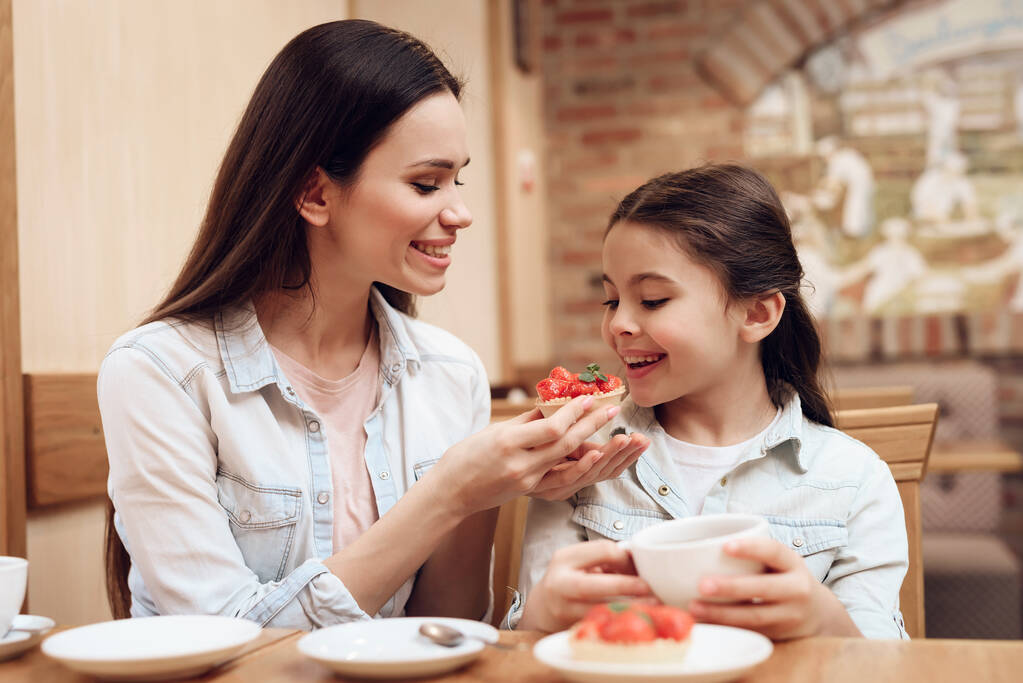 Mutter mit Tochter isst Kuchen in Cafeteria. - Foto, Bild