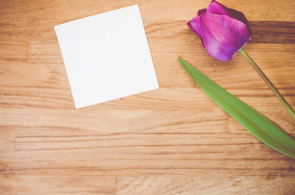 Высокий угол съемки фиолетового тюльпана и клочка бумаги на деревянной поверхности - пространство для копирования - Фото, изображение