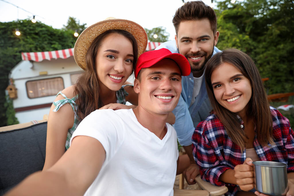 Šťastní přátelé vezou Selfie blízko přívěsu. Camping season - Fotografie, Obrázek