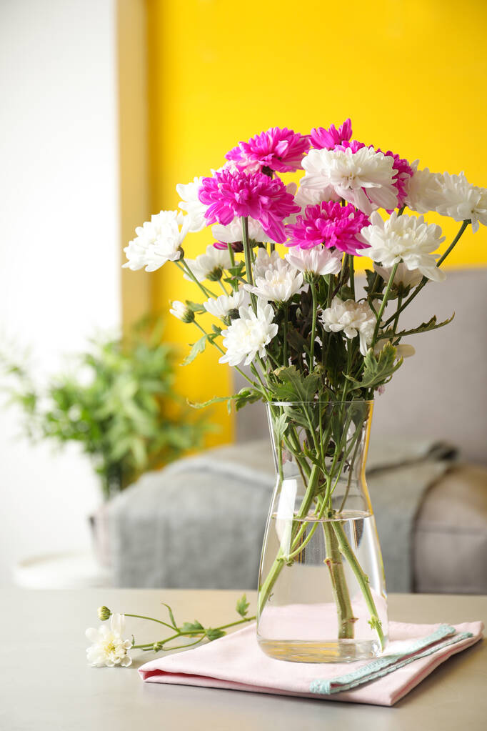 Kaunis kimppu krysanteemi kukkia harmaa pöytä sisätiloissa. Sisustus - Valokuva, kuva