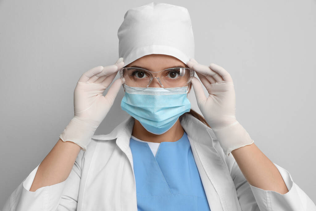 医者で保護マスクと医療用手袋の上に置く眼鏡に光グレーの背景 - 写真・画像