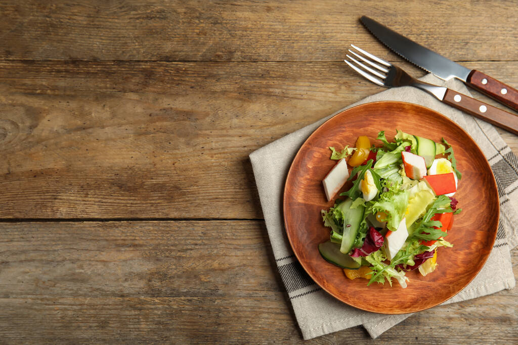Köstlicher Salat mit Krabbenspießen und Salat auf Holztisch, flach gelegt. Raum für Text - Foto, Bild