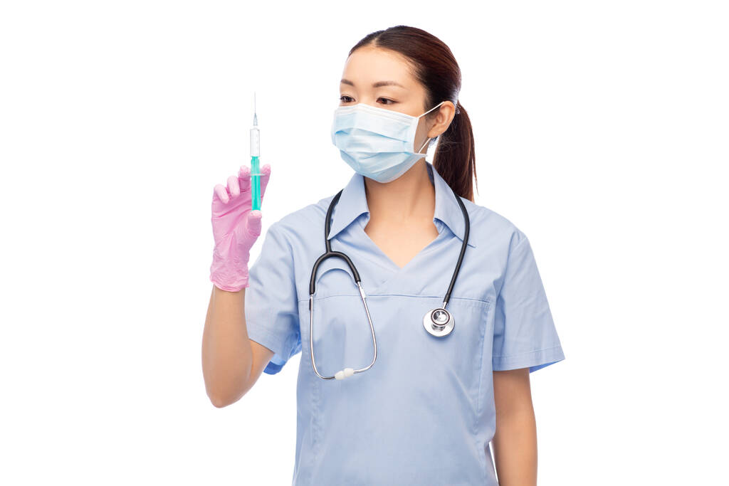 aasialainen sairaanhoitaja naamiossa lääkkeellä ruiskussa - Valokuva, kuva