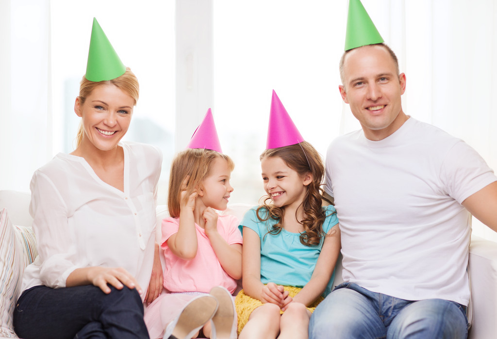 gelukkig gezin met twee kinderen in hoeden vieren - Foto, afbeelding