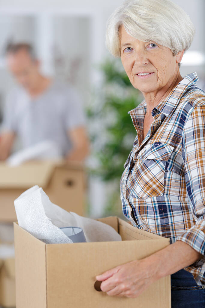 mujer mayor alegre y tranquila sosteniendo una caja - Foto, imagen