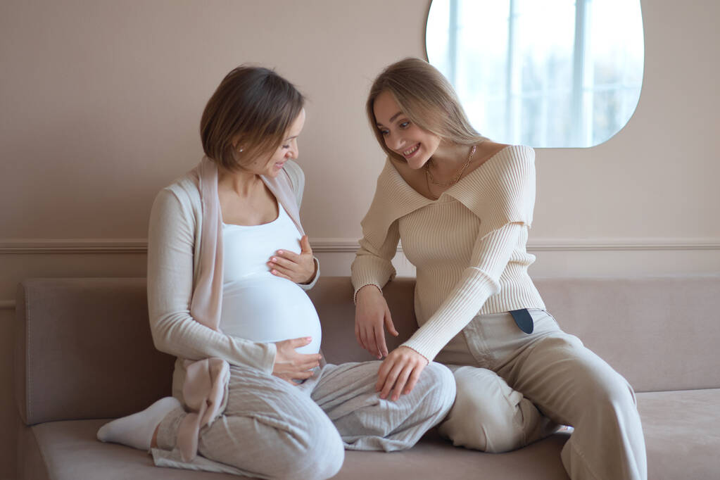 Usmívající se žena dotýkající se břicha těhotné přítelkyně - Fotografie, Obrázek