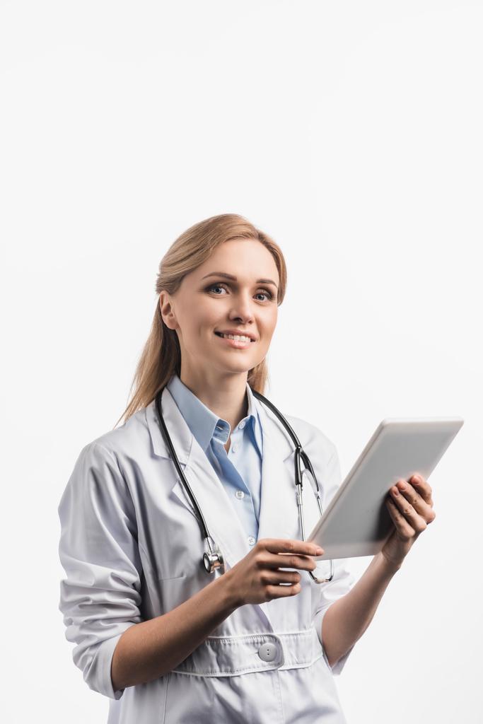 infermiera allegra in camice bianco utilizzando tablet digitale isolato su bianco - Foto, immagini