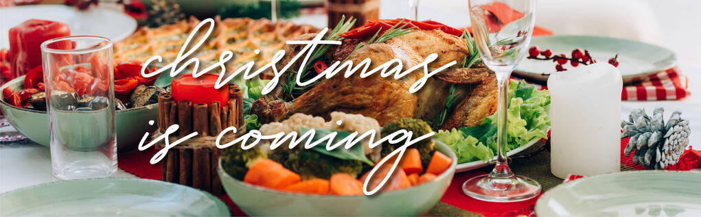 Tisch mit leckerem Kuchen, gebratenem Truthahn und Gemüse kurz vor Weihnachten kommt Schriftzug in der Nähe von Kerzen, Banner - Foto, Bild