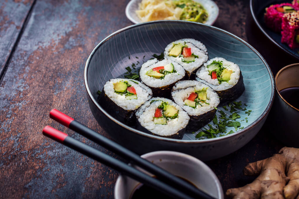 közeli kilátás ízletes tekercsek, sushi és maki evőpálcikákkal  - Fotó, kép