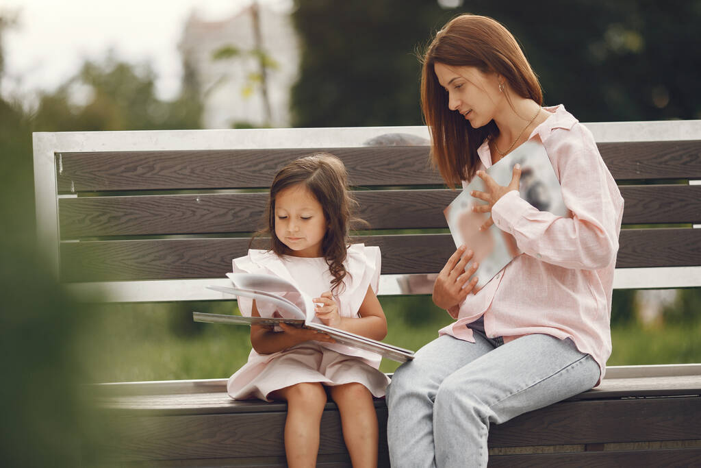 Madre con hija leyendo un libro en la ciudad - Foto, imagen
