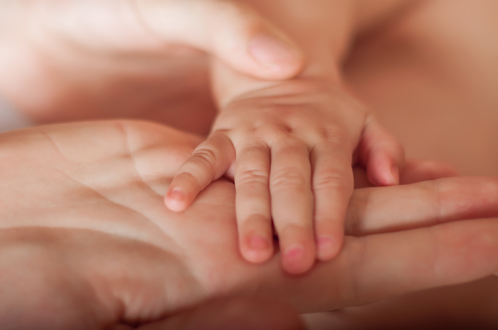 mano de bebé en las manos de la madre primer plano
 - Foto, imagen