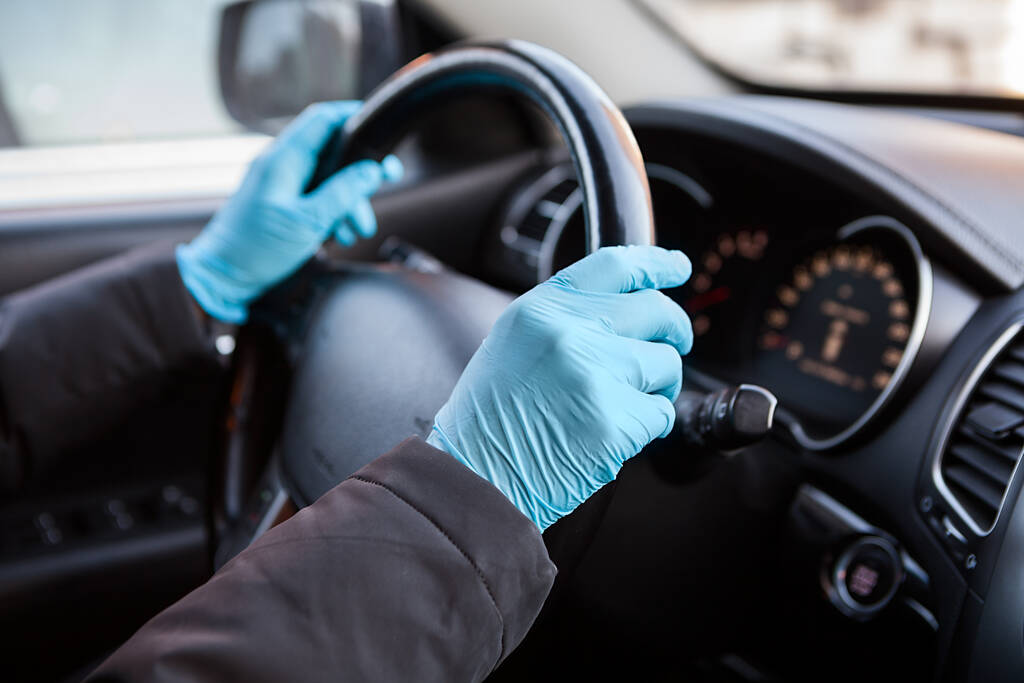 Mains de conducteur en gants de caoutchouc bleu tenant le volant de la voiture, vue rapprochée - Photo, image