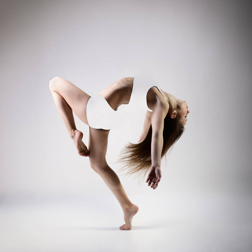 Tanssi. Nuori kaunis siro nainen täydellinen hoikka urheilullinen kehon tanssia ja hyppäämällä studiossa yli harmaa tausta. Nainen kaunis nykytanssi. Liikkumisen helppous, nuoruus, armo, nivelkivunlievitys ja liike abstrakti käsitteellinen muotoilu - Valokuva, kuva