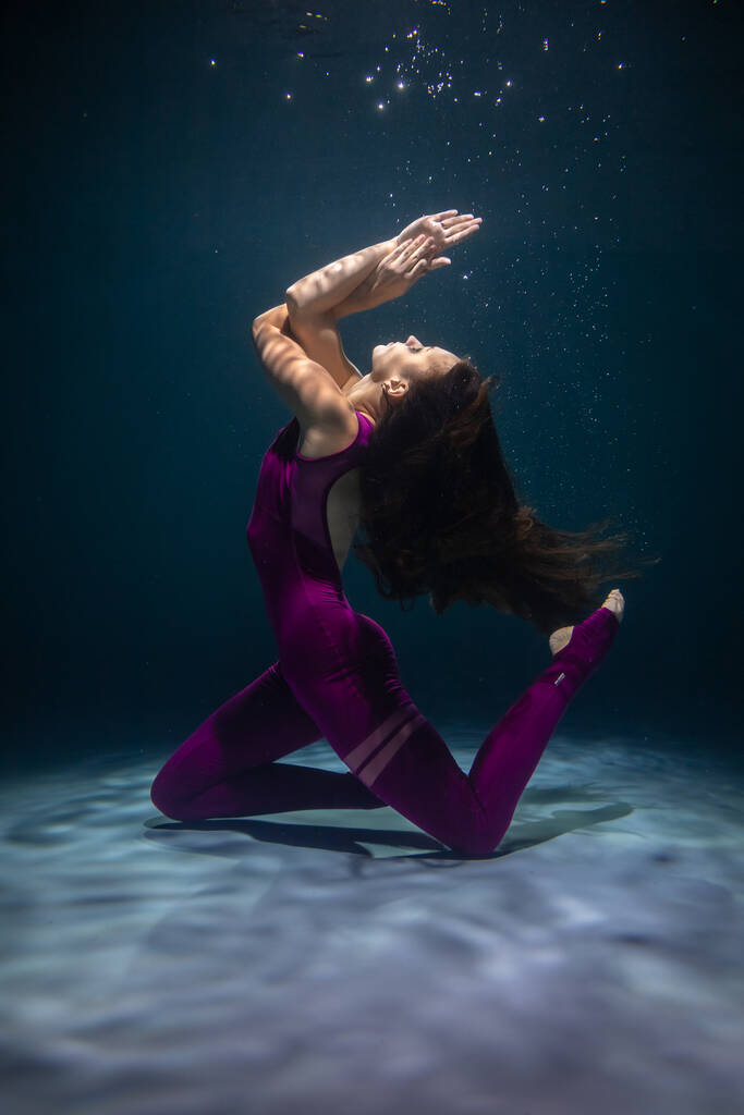 Το κορίτσι κάνει γιόγκα κάτω από το νερό με αθλητικά ρούχα. Ασάνα και Διαλογισμός - Φωτογραφία, εικόνα