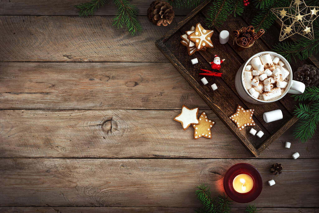 ホットドリンク、マシュマロ、ジンジャーブレッドクッキーと木製のテーブル、トップビュー、コピースペースのろうそくとクリスマスの組成物。クリスマスと冬の休暇｜coziness Concept. - 写真・画像