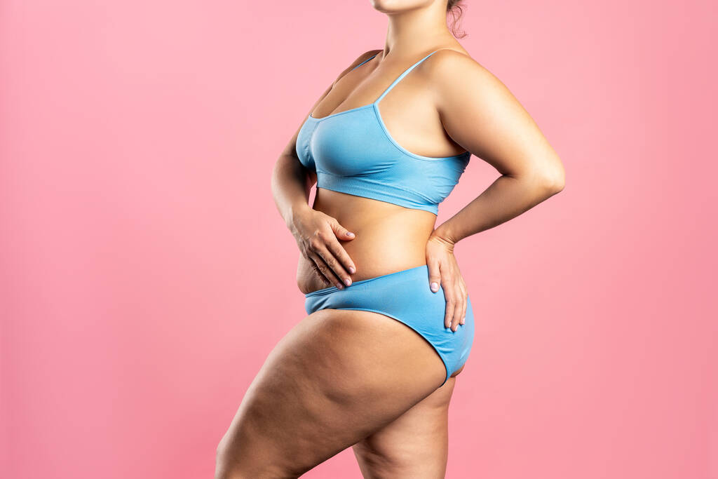 Mujer gorda en ropa interior azul sobre fondo rosa, cuerpo femenino con sobrepeso, plano de estudio con espacio para copiar - Foto, Imagen