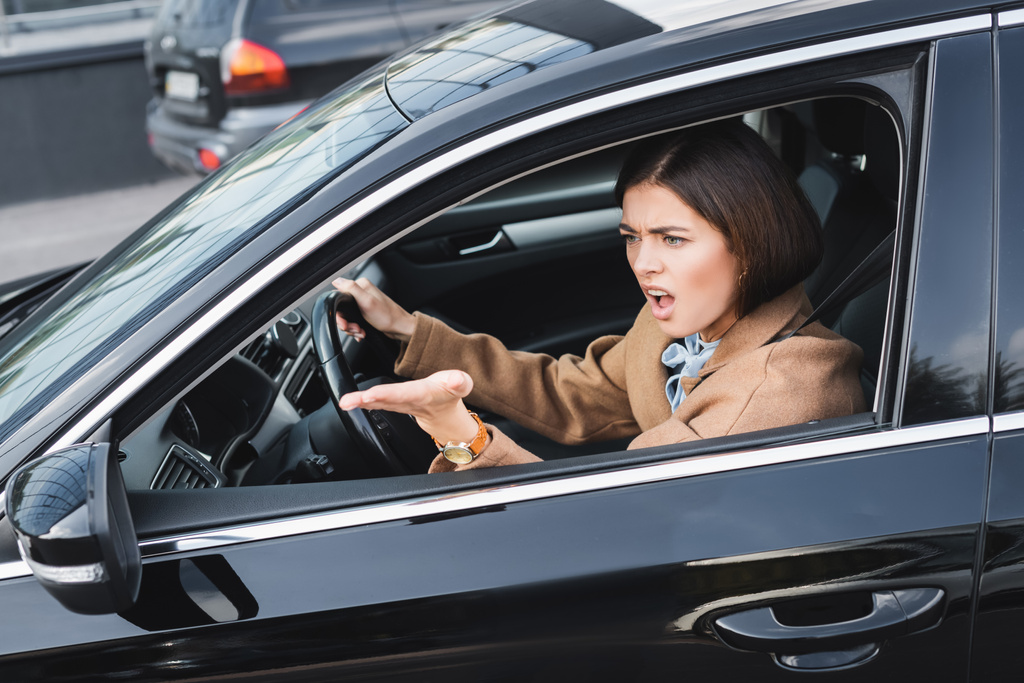 dühös nő sikoltozó és mutató kézzel oldalsó ablakból vezetés közben autó - Fotó, kép