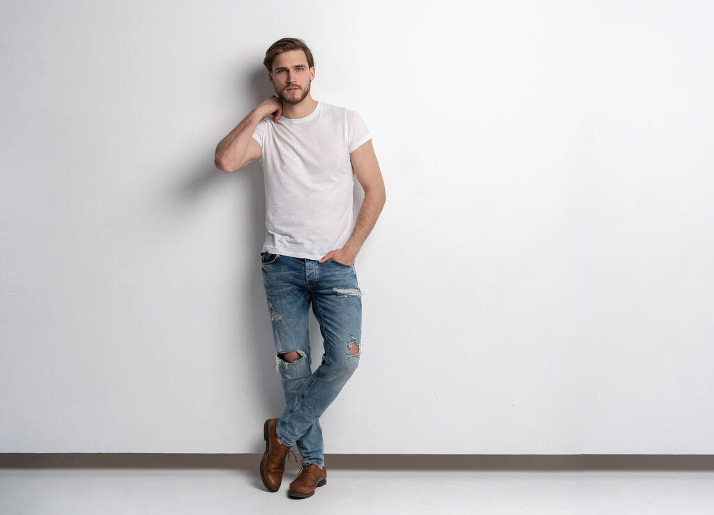 Full length studio πορτρέτο του casual νέου άνδρα με τζιν και πουκάμισο. Απομονωμένα σε λευκό φόντο. - Φωτογραφία, εικόνα