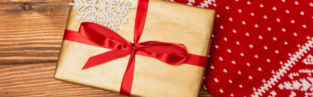 vue du haut de la boîte cadeau et écharpe tricotée rouge sur fond en bois, bannière - Photo, image