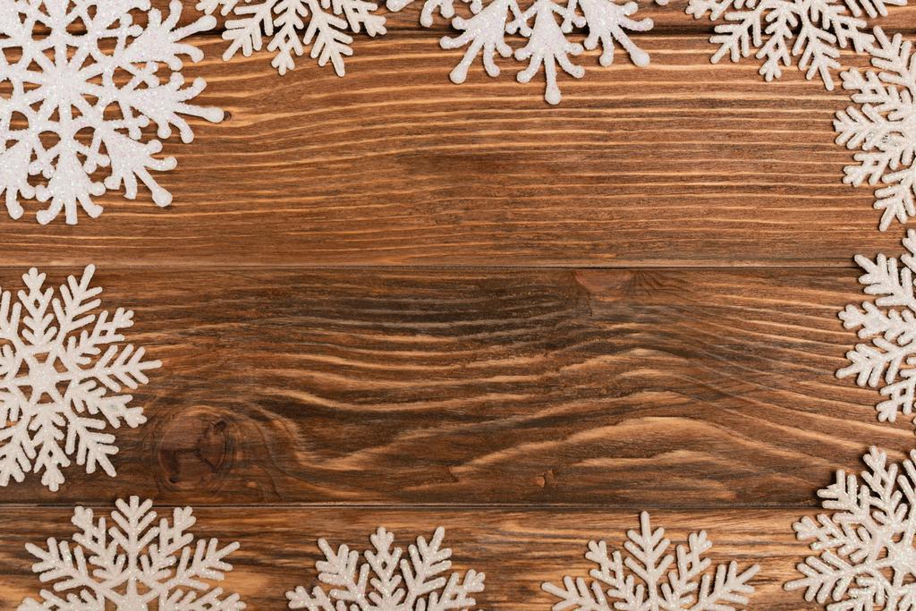 vrchní pohled na zimní sněhové vločky na dřevěném pozadí - Fotografie, Obrázek