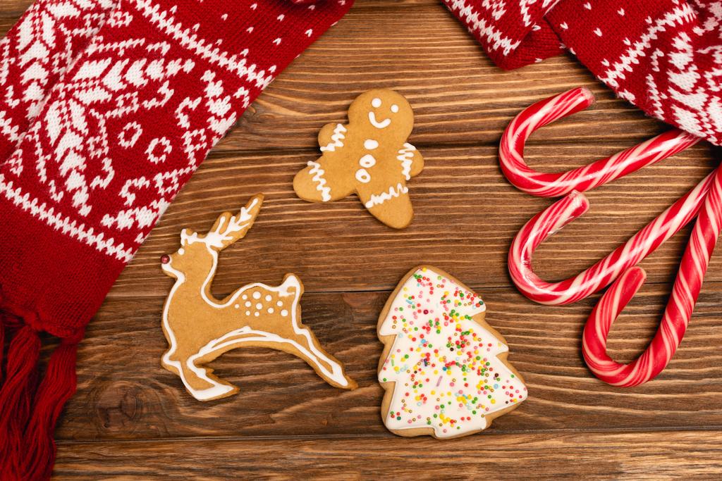 top view of winter gingerbread cookies and scarf on wooden background - Photo, Image