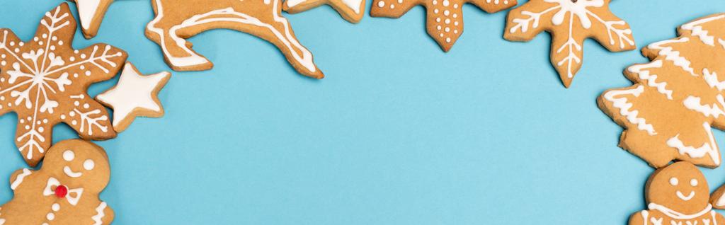 bovenaanzicht van winterpeperkoek koekjes op blauwe achtergrond, banner - Foto, afbeelding
