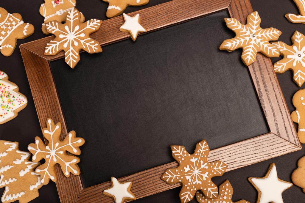 top view of gingerbread cookies and chalkboard on black background - Photo, Image