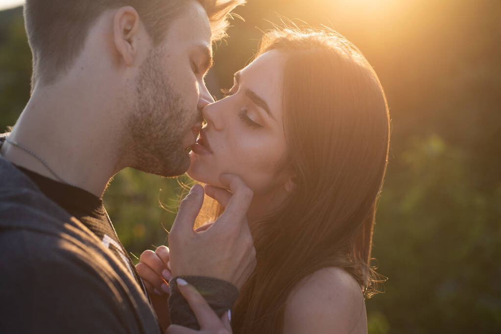 Beijo sensual. Casal jovem beijando e fazendo amor. Beija os amantes. Retrato de um belo jovem casal esperando para beijar contra a luz do pôr do sol. - Foto, Imagem