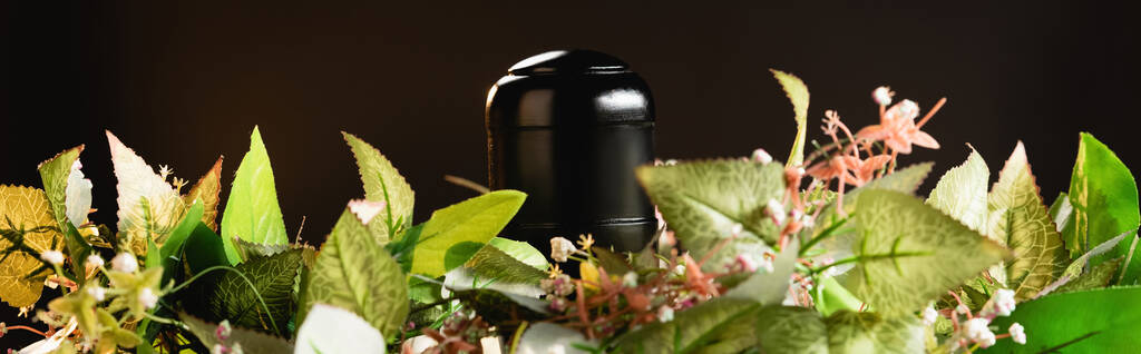 bouquet e urna con cenere su sfondo nero, concetto di funerale, banner - Foto, immagini