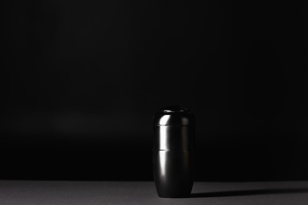 Urne mit Asche auf schwarzem Hintergrund, Bestattungskonzept - Foto, Bild