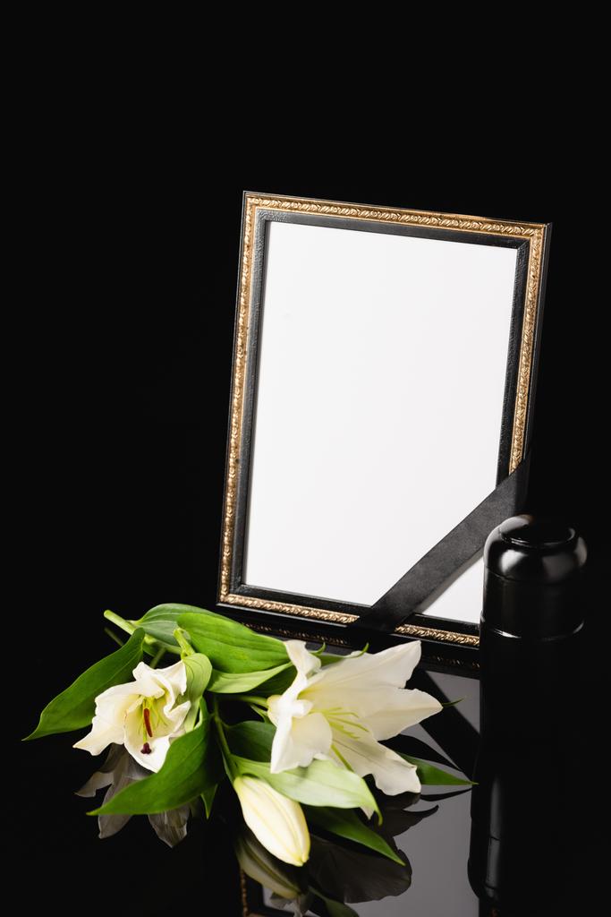 květiny, zrcadlo s černou stuhou a urna s popelem na černém pozadí, pohřební koncept - Fotografie, Obrázek