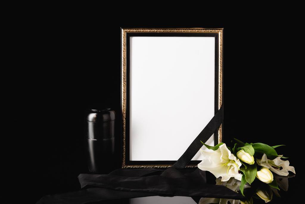 flowers, mirror with black ribbon and urn with ashes on black background, funeral concept - Photo, Image