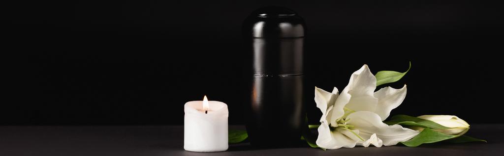 lilie, svíčka a urna s popelem na černém pozadí, koncept pohřbu, prapor - Fotografie, Obrázek