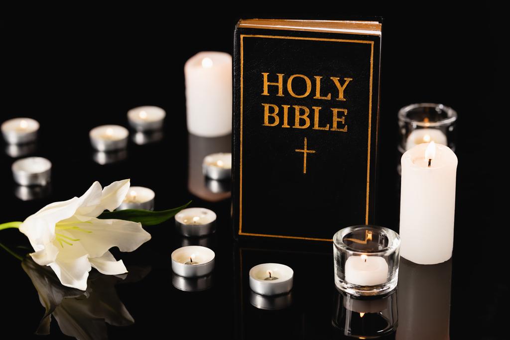 lilia, świece i święta Biblia na czarnym tle, koncepcja pogrzebu - Zdjęcie, obraz