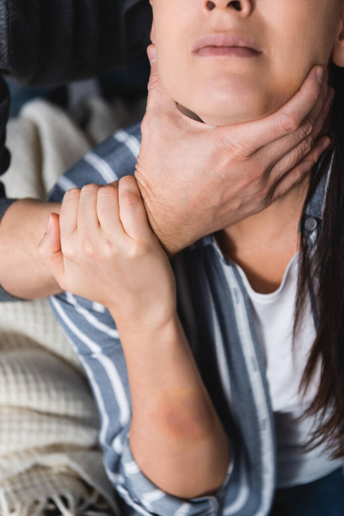 Cropped view of abuser choking wife with bruise on hand  - Photo, Image