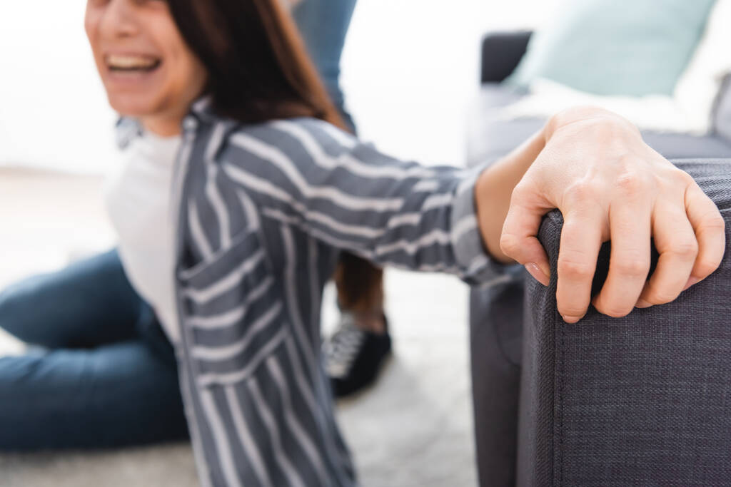 Screaming woman touching couch near abusive husband on blurred background  - Photo, Image