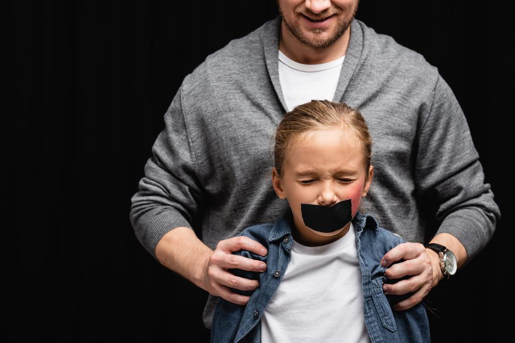 Sorrindo abusado abraçando filha com fita adesiva e hematoma isolado em preto  - Foto, Imagem