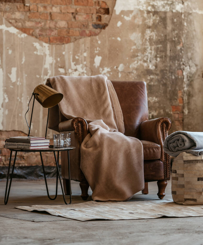 革のソファの上のベージュの毛布の居心地の良い景色を元の部屋の真ん中に - 写真・画像
