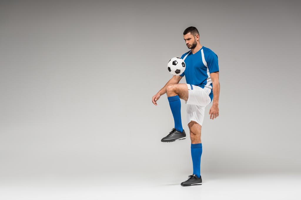灰色の背景にサッカーとひげそりのスポーツマンのトレーニング  - 写真・画像