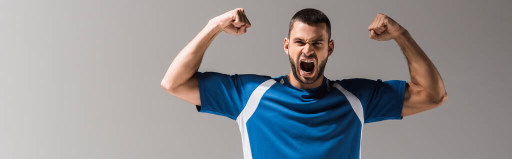 Возбужденный спортсмен с открытым ртом показывает да жест изолирован на сером, баннер  - Фото, изображение