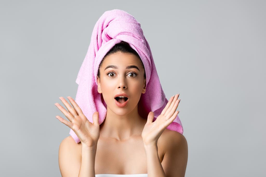 wstrząśnięta piękna kobieta z ręcznikiem na włosach odizolowana na szarości - Zdjęcie, obraz