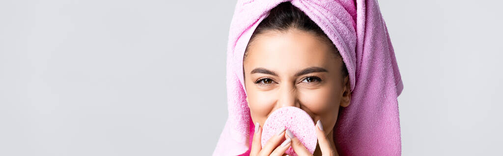smiling beautiful woman with towel on hair and sponge isolated on grey, banner - Photo, Image