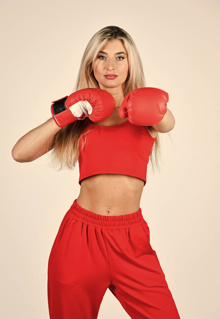 Samodoskonalenie. Sportowa dziewczyna czerwone ubrania rękawice bokserskie. Siłownia i trening. Model sprawności. Sportowa trenerka fitness. Pokonać problemy. Szkolenie osobiste. Walcz z własnym kompleksem. Styl życia sportowego - Zdjęcie, obraz