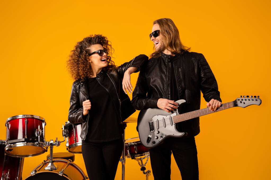 Portrait famous positive man woman rock group team man hold electric guitar enjoy performing new solo composition wear black leather jacket sunglass isolated bright shine color background - Photo, Image